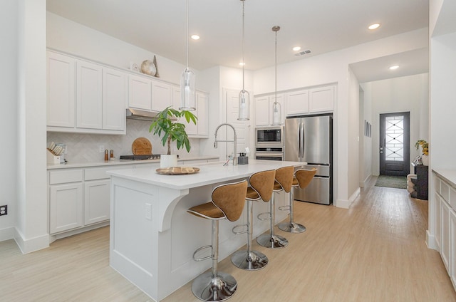 627 Brockwell Bnd, Forney, TX 75126 - kitchen featuring stainless steel appliances, light wood finished floors, decorative backsplash, white cabinetry, and recessed lighting