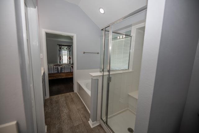107 Harvest Way, Crandall, TX 75114 - bathroom with connected bathroom, vaulted ceiling, wood finished floors, a stall shower, and a garden tub