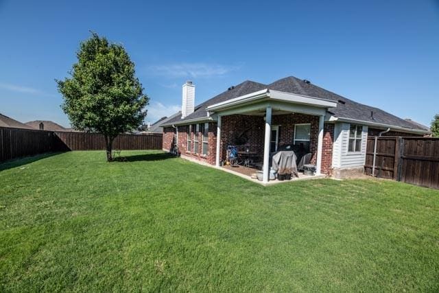 107 Harvest Way, Crandall, TX 75114 - back of property with a chimney and brick siding