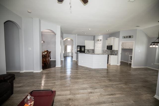 107 Harvest Way, Crandall, TX 75114 - living room with arched walkways, a ceiling fan, baseboards, and wood finished floors