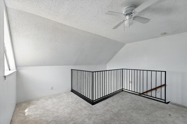 bonus room with a textured ceiling, carpet, vaulted ceiling, and ceiling fan