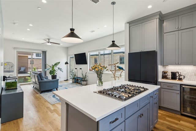13900 Noel Rd Unit 401, Dallas, TX 75240 - kitchen featuring wine cooler, stainless steel gas stovetop, gray cabinetry, light countertops, and recessed lighting