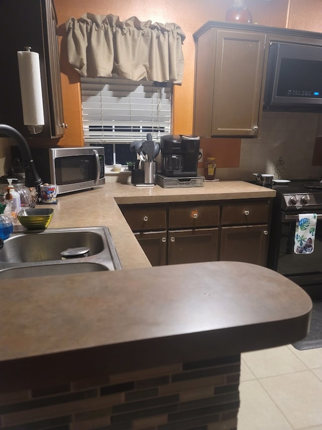 4531 Blackstone Dr, Fort Worth, TX 76114 - kitchen featuring black electric range oven, stainless steel microwave, a sink, decorative backsplash, and light countertops