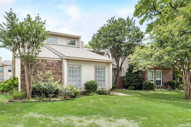 13156 Burninglog Ln, Dallas, TX 75243 - view of front facade with brick siding, a front lawn, a shingled roof, and stucco siding