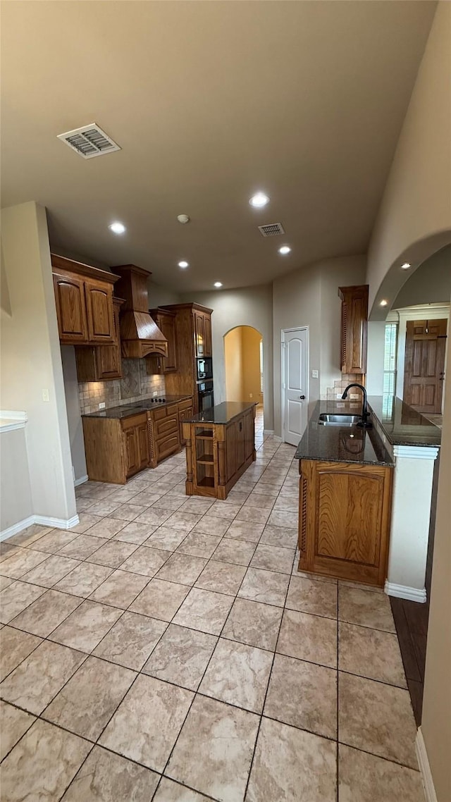 124 Heritage Pkwy W, Decatur, TX 76234 - kitchen featuring arched walkways, a sink, custom range hood, decorative backsplash, and recessed lighting