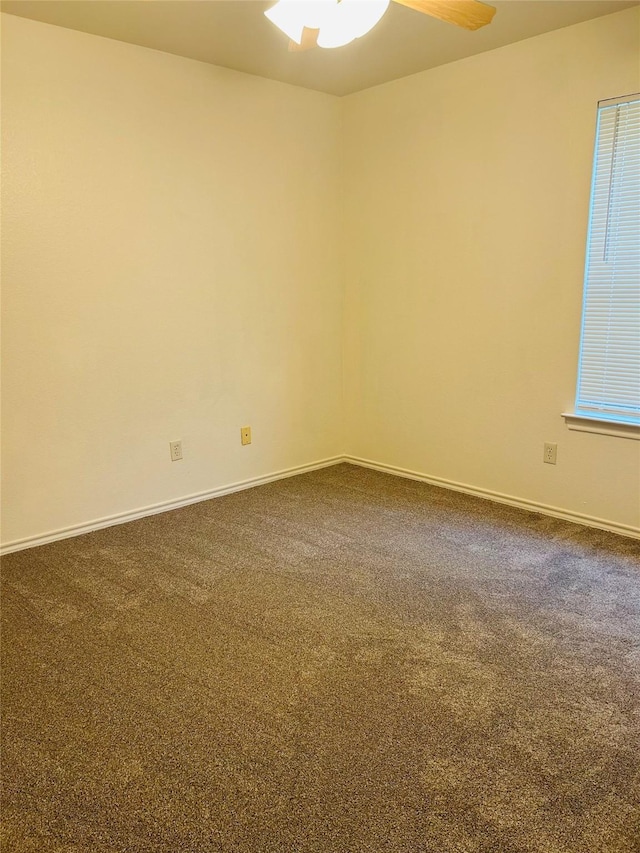 601 Lawrence Ave, Terrell, TX 75160 - empty room with a ceiling fan, dark colored carpet, and baseboards