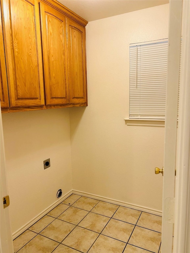 601 Lawrence Ave, Terrell, TX 75160 - clothes washing area with hookup for an electric dryer, cabinet space, light tile patterned floors, and baseboards