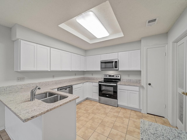 3920 Saint Christopher Ln, Dallas, TX 75287 - kitchen with appliances with stainless steel finishes, a sink, a peninsula, light tile patterned floors, and white cabinets