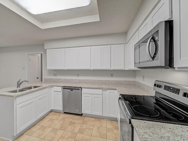3920 Saint Christopher Ln, Dallas, TX 75287 - kitchen featuring stainless steel appliances, a sink, light tile patterned flooring, a peninsula, and white cabinets