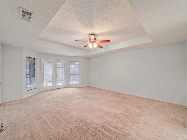 3920 Saint Christopher Ln, Dallas, TX 75287 - spare room with a tray ceiling, a textured ceiling, a ceiling fan, light carpet, and baseboards