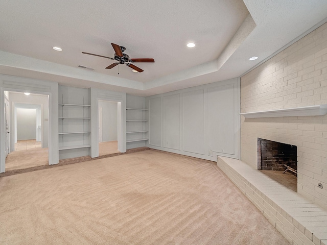 3920 Saint Christopher Ln, Dallas, TX 75287 - unfurnished living room featuring light colored carpet, ceiling fan, built in shelves, a fireplace, and recessed lighting