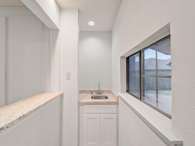 3920 Saint Christopher Ln, Dallas, TX 75287 - bathroom with a textured ceiling, a textured wall, and vanity