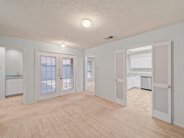 3920 Saint Christopher Ln, Dallas, TX 75287 - unfurnished room with french doors, light colored carpet, a sink, a textured ceiling, and baseboards