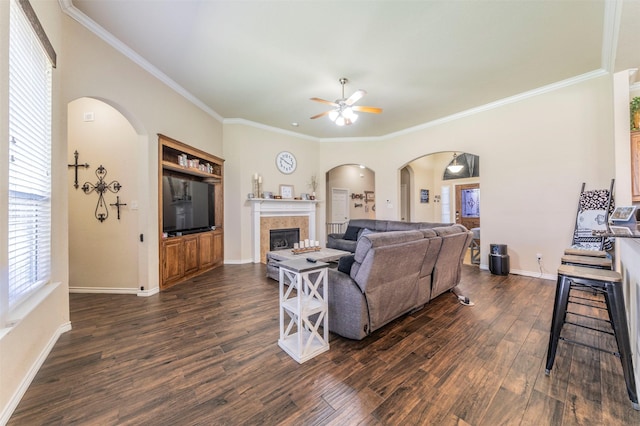2113 Old Foundry Rd, Weatherford, TX 76087 - living room with arched walkways, ceiling fan, ornamental molding, dark wood-style floors, and a tile fireplace