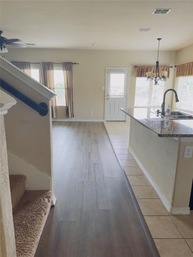 1129 Autumnwood Dr, Azle, TX 76020 - kitchen featuring a sink, a chandelier, a ceiling fan, light wood-style flooring, and hanging light fixtures
