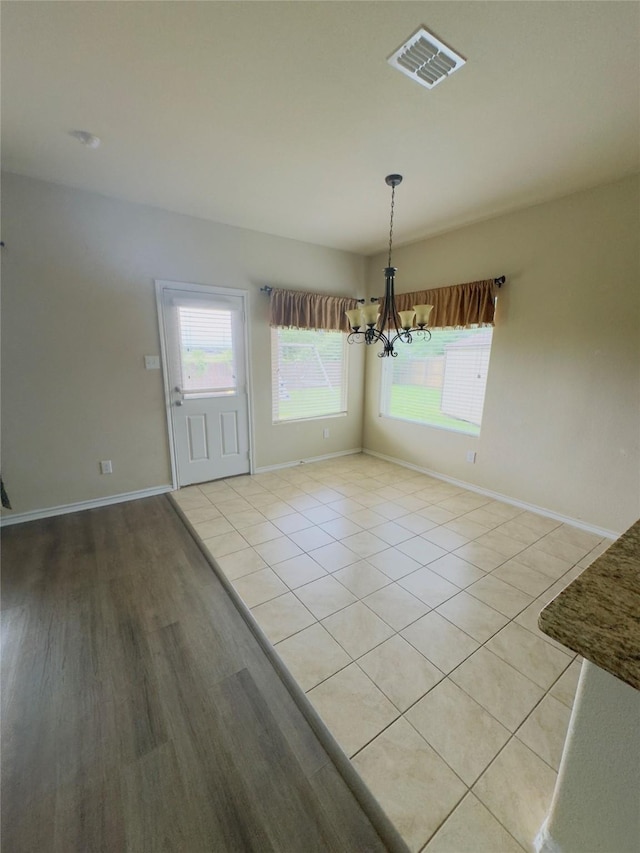 1129 Autumnwood Dr, Azle, TX 76020 - unfurnished dining area with a chandelier, plenty of natural light, and baseboards