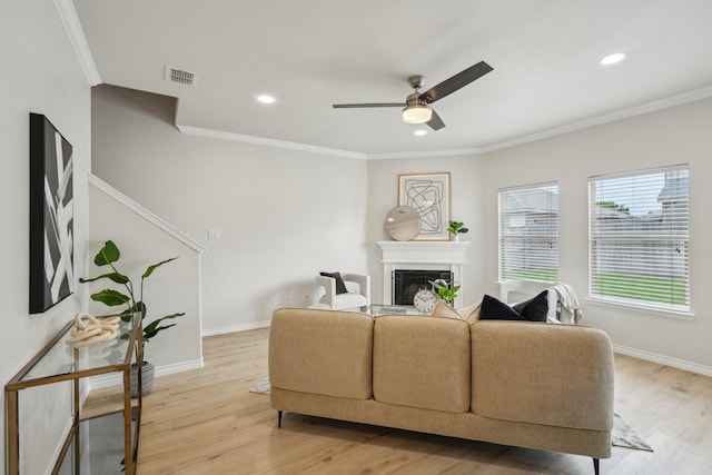 12350 Orloff Dr, Rhome, TX 76078 - living room with a glass covered fireplace, light wood finished floors, a ceiling fan, crown molding, and baseboards