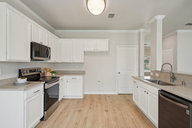 12350 Orloff Dr, Rhome, TX 76078 - kitchen featuring appliances with stainless steel finishes, a sink, ornamental molding, light wood-style floors, and white cabinets