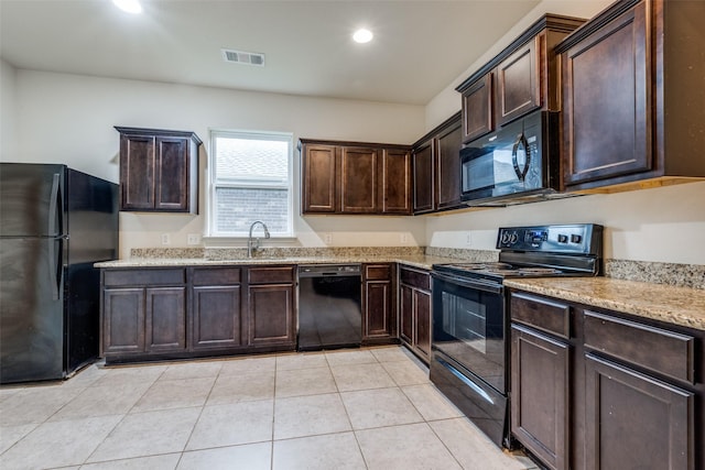 4601 Shy Creek Ln, Denton, TX 76207 - kitchen with black appliances, dark brown cabinetry, light stone countertops, recessed lighting, and light tile patterned flooring
