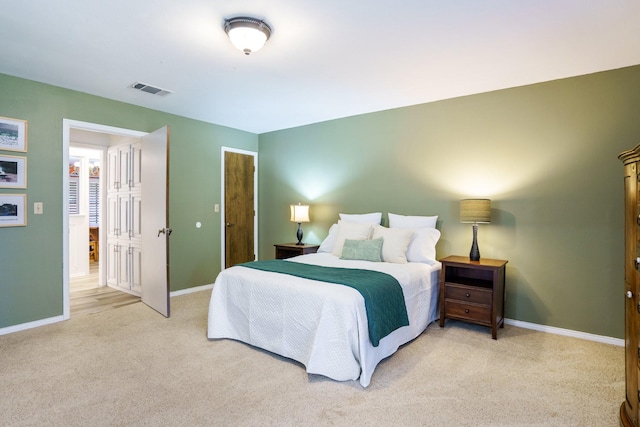 bedroom featuring light carpet and baseboards