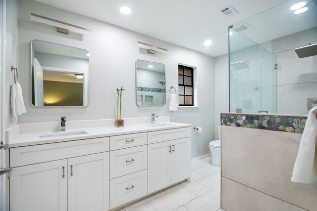 full bath with tiled shower, toilet, recessed lighting, and double vanity