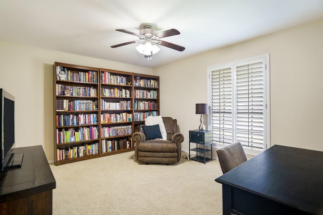 carpeted home office with a ceiling fan