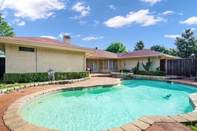 view of pool featuring fence, a pool with connected hot tub, and a patio