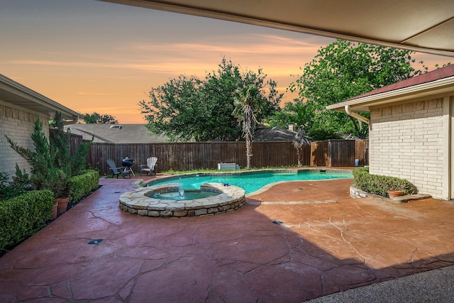 view of pool with a fenced backyard, a patio, and a pool with connected hot tub