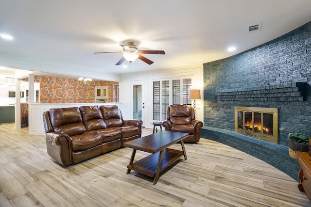 living area featuring ceiling fan, wood finished floors, a brick fireplace, and recessed lighting