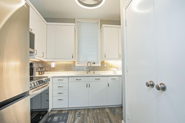 4040 Avondale Ave Unit 302, Dallas, TX 75219 - kitchen featuring stainless steel appliances, a sink, dark wood-style flooring, light countertops, and white cabinetry