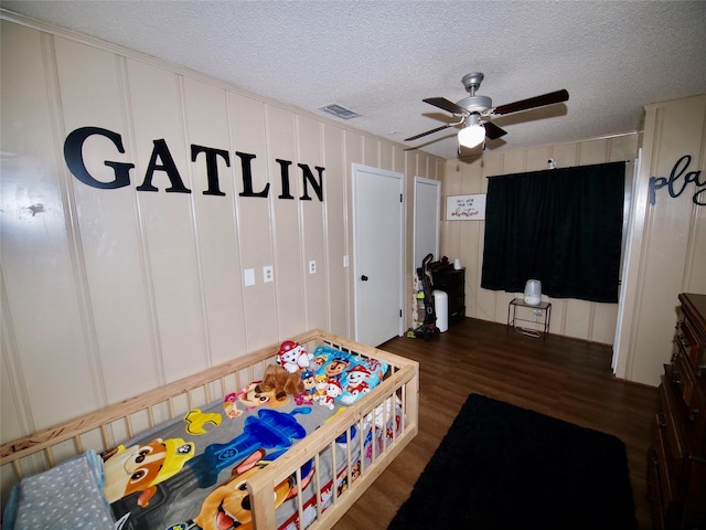 804 Austin Rd, Graham, TX 76450 - bedroom with wood finished floors, a textured ceiling, a ceiling fan, and a decorative wall