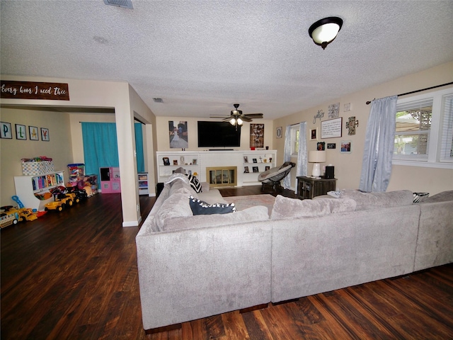 804 Austin Rd, Graham, TX 76450 - living room with a textured ceiling, ceiling fan, wood finished floors, and a glass covered fireplace