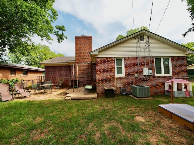 804 Austin Rd, Graham, TX 76450 - back of house featuring a patio area, brick siding, central air condition unit, a yard, and a chimney
