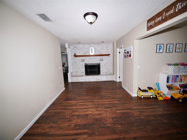 804 Austin Rd, Graham, TX 76450 - living area featuring wood finished floors, a textured ceiling, a brick fireplace, and baseboards