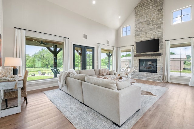 1299 Harmony Cir, Weatherford, TX 76087 - living room featuring high vaulted ceiling, a fireplace, wood finished floors, and ceiling fan