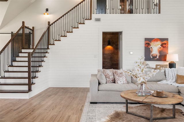 1299 Harmony Cir, Weatherford, TX 76087 - living room featuring wood finished floors, stairway, baseboards, brick wall, and wooden walls