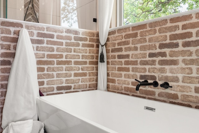1299 Harmony Cir, Weatherford, TX 76087 - bathroom view of a freestanding bath and brick wall
