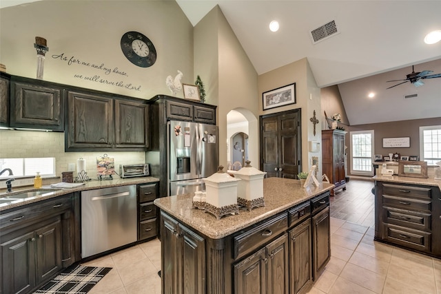3325 Creek Rd, Keller, TX 76248 - kitchen with appliances with stainless steel finishes, high vaulted ceiling, a ceiling fan, arched walkways, and decorative backsplash