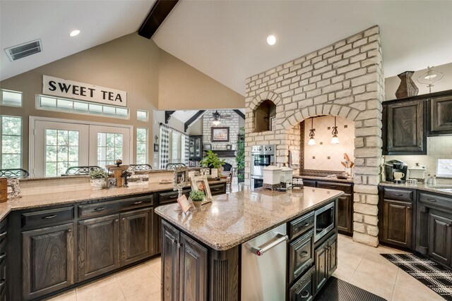 3325 Creek Rd, Keller, TX 76248 - kitchen with decorative backsplash, light tile patterned floors, stainless steel microwave, light stone counters, and beam ceiling