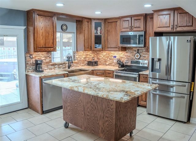 7016 Buttonwood Dr, Fort Worth, TX 76137 - kitchen with stainless steel appliances, a sink, brown cabinets, light stone counters, and recessed lighting