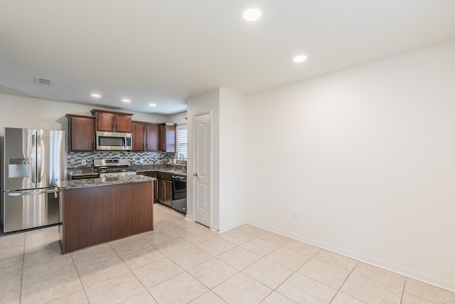 3001 Rocking Hills Trl, Forney, TX 75126 - kitchen with appliances with stainless steel finishes, a center island, dark stone countertops, recessed lighting, and tasteful backsplash