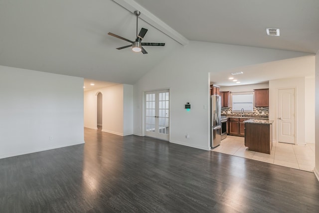3001 Rocking Hills Trl, Forney, TX 75126 - unfurnished living room with ceiling fan, light wood-style flooring, arched walkways, beam ceiling, and high vaulted ceiling