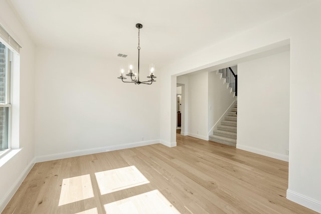 1024 Emerald Trace Dr, Justin, TX 76247 - unfurnished room featuring a chandelier, light wood-type flooring, stairs, and healthy amount of natural light