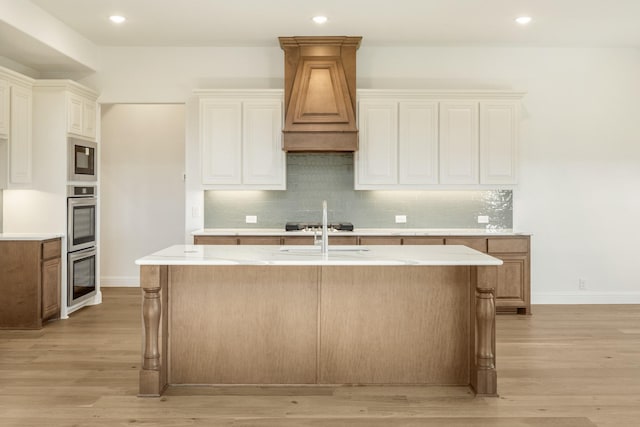 1024 Emerald Trace Dr, Justin, TX 76247 - kitchen featuring light wood-style floors, decorative backsplash, a kitchen island with sink, a sink, and recessed lighting
