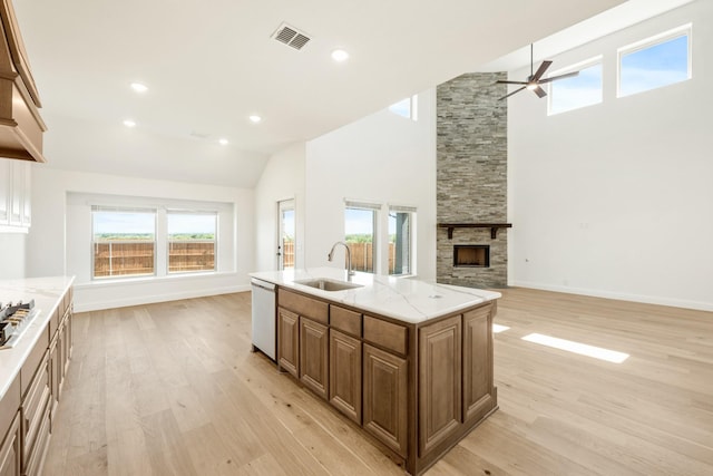 1024 Emerald Trace Dr, Justin, TX 76247 - kitchen with a sink, ceiling fan, light wood-type flooring, open floor plan, and a fireplace