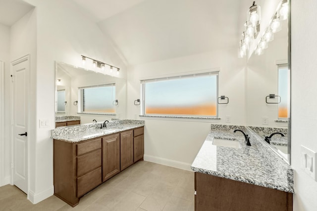 1024 Emerald Trace Dr, Justin, TX 76247 - bathroom featuring two vanities, lofted ceiling, tile patterned floors, and baseboards