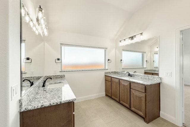 1024 Emerald Trace Dr, Justin, TX 76247 - bathroom with vaulted ceiling, two vanities, baseboards, and tile patterned flooring