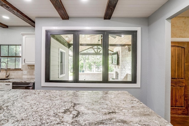 132 S Briaroaks Rd, Burleson, TX 76028 - kitchen featuring a sink, a textured wall, white cabinetry, beamed ceiling, and light stone countertops
