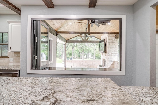 132 S Briaroaks Rd, Burleson, TX 76028 - kitchen view of beam ceiling, ceiling fan, white cabinetry, light stone counters, and tasteful backsplash