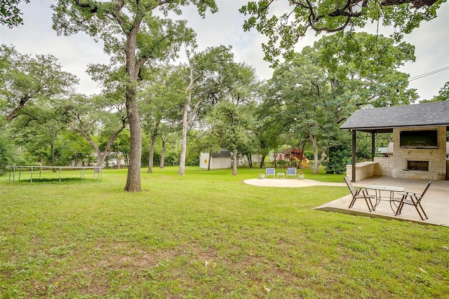 132 S Briaroaks Rd, Burleson, TX 76028 - view of green lawn with a trampoline, an outdoor stone fireplace, a patio area, and a playground